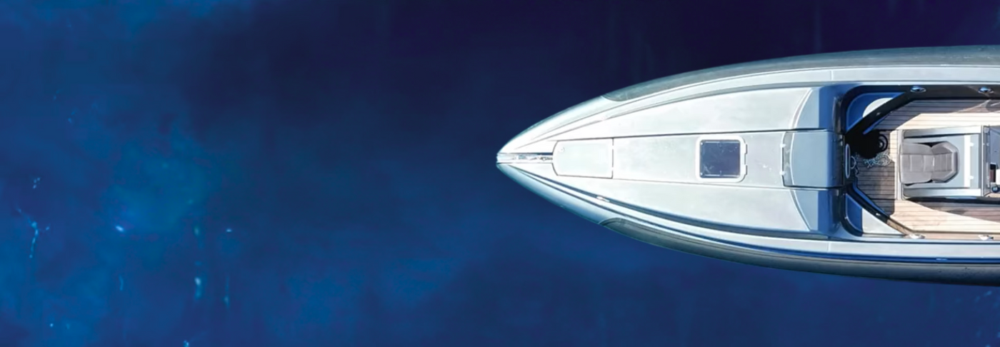 Aerial view of a yacht's bow cutting through the water.